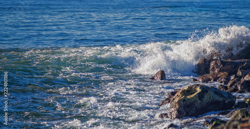 Breaking Ocean Wave and Froth on Rocks in Waikiki Hawaii.