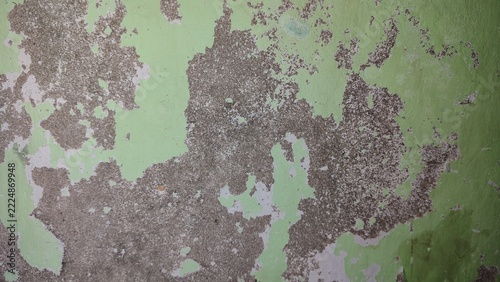 Obraz na plátně Weathered green wall surface with peeling paint layers and textured damage desig