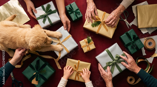 Overhead Multigenerational Christmas Wrapping Activity with Family Hands, Playful Puppy and Gift Boxes