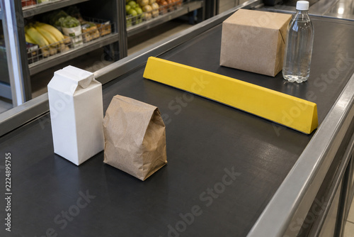 Yellow Checkout Divider Between Packages on a Supermarket Conveyor Belt