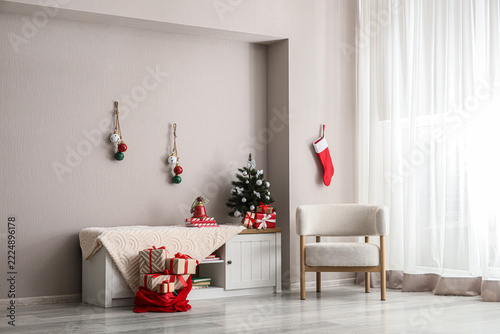 Christmas home interior with festive decorations, small tree and gift boxes, ...