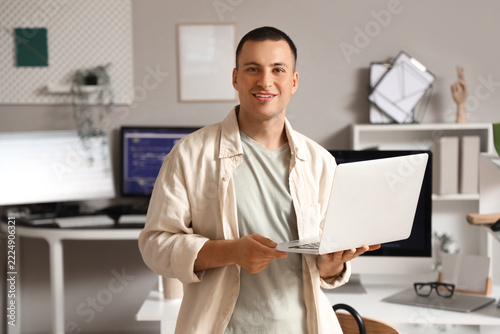 Remote work and digital nomad lifestyle, young man holding laptop in modern h...