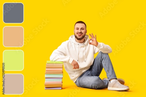 Education and student success, happy young man sitting with a stack of books ...