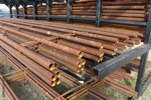 Fotografie Rows of rusty steel pipe stored on an outdoor pipe rack