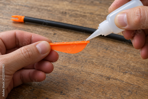 Applying adhesive to the mounting edge of an arrow vane