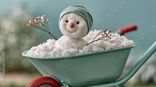 Happy snowman riding in snow-filled wheelbarrow