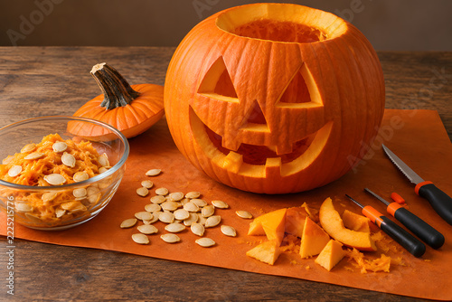 Fotografie Carved Halloween pumpkin with seeds and carving tools