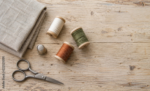 Sewing tools and thread spools on a wooden table