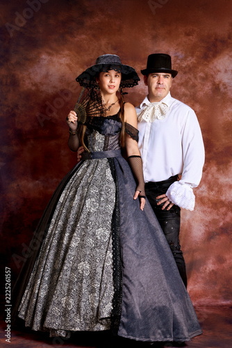 Vintage couple portrait in 19th-century Victorian attire and classic hats