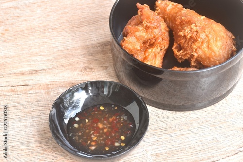 crispy fried chop salty chicken wing and leg in black lunch box dipping sweet chili sauce in cup on table