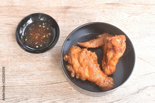 crispy fried chop salty chicken wing and leg in black lunch box dipping sweet chili sauce in cup on table