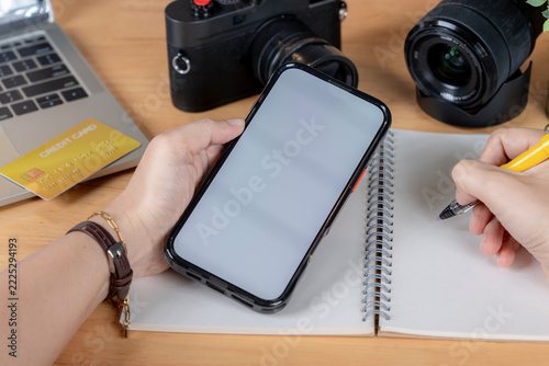 Close-up of a woman holding a smartphone with a blank screen for app mockup and graphic design display.
