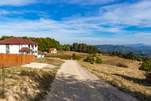 Dirt road leading to rural houses in Balkan mountain village