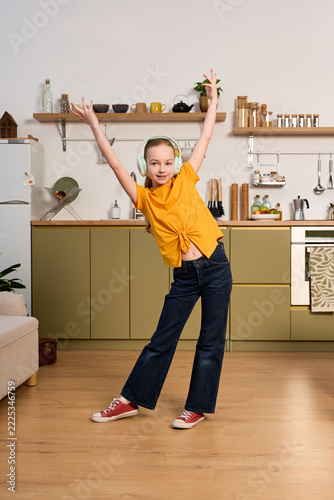 Joyful preteen girl enjoying her weekend in a cozy, bright kitchen