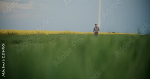 Young man standing in a yellow flower field