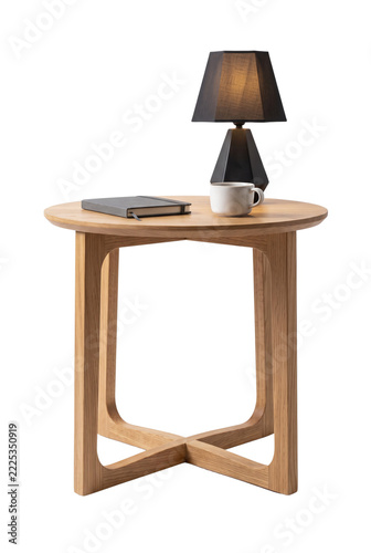 Round wooden side table with black lamp notebook and coffee mug