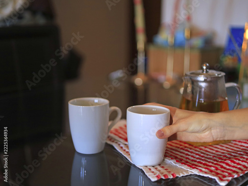 Hand holding a white mug, food and beverage service with ceramic drinkware for a tea break in a home kitchen.