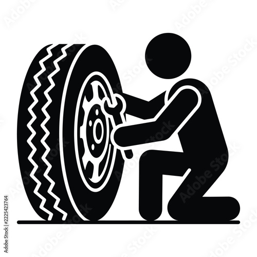 Mechanic kneeling and using a wrench to repair a vehicle tire