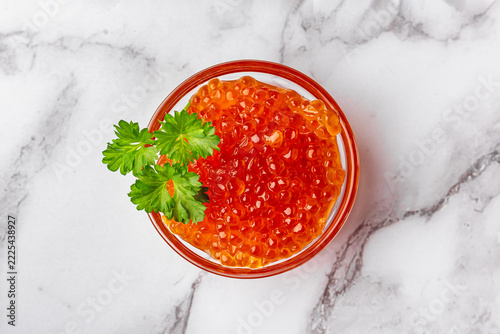 Elegant food composition with red caviar and parsley