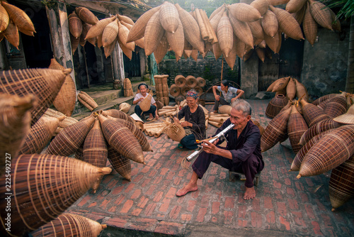 Obraz na plátně Vietnamese fishermen are doing basketry for fishing equipment at morning in Thu Sy Village, Vietnam