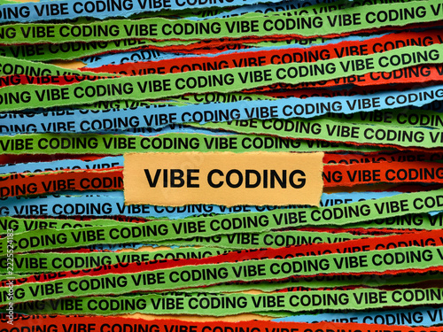 Strips of colorful paper with the words Vibe Coding typed on them. Close up.