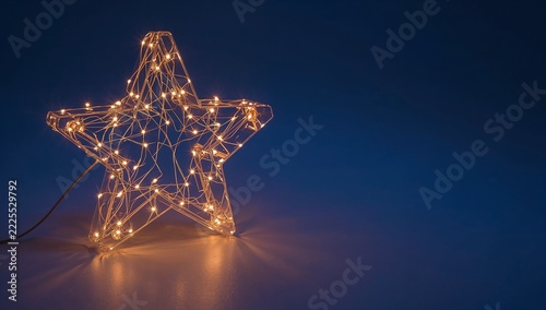 A lighted star on a table with a blue background