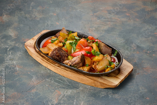 A sizzling mix of grilled meat and vegetables served on a hot
