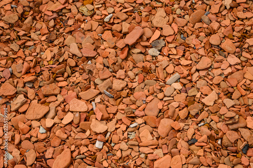 Small irregular shaped stone fragments near body of water.