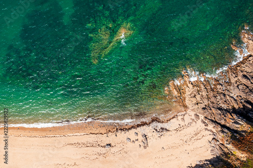 The beautiful French coastline along the Atlantic Ocean in Brittany, with rocks, azure water, and sand—a drone view.