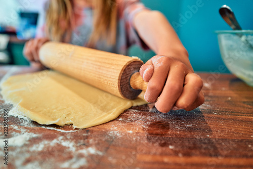 Obraz na plátně Hand Gripping a Wooden Rolling Pin Over Flat Dough