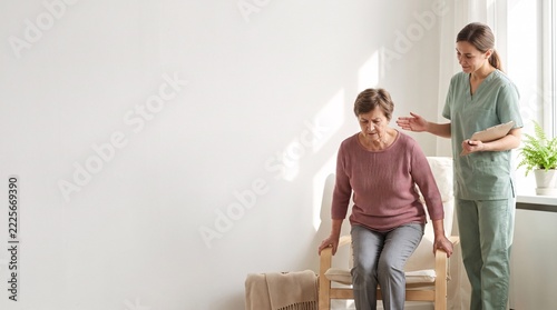 Geriatric care: Healthcare worker guides senior patient through sit-to-stand mobility exercise at home