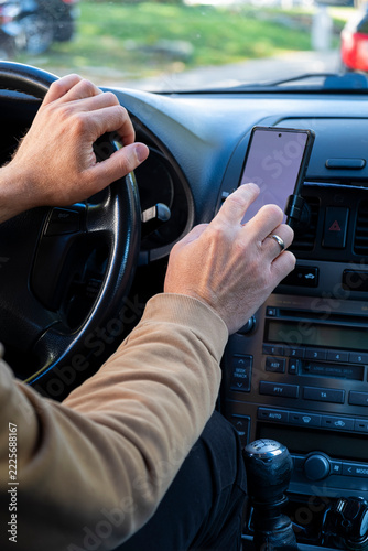 Close-Up of a Man Using a Smartphone for Navigation While Driving.
