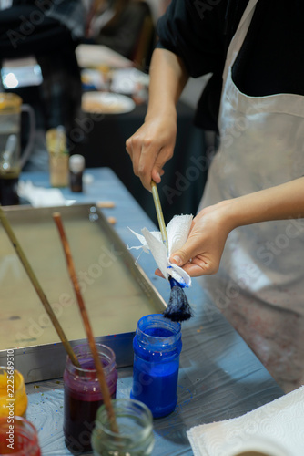 Artist Cleaning Paintbrush After Using Blue Pigment in Traditional Turkish Ebru Workshop