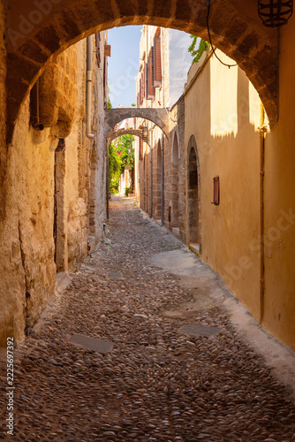 Narrow Cobblestone Street with Stone Arches in Rhodes Old Town, Greece