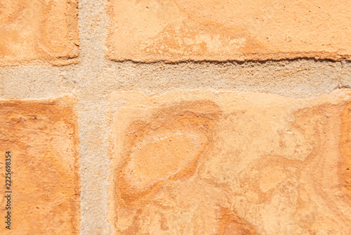 Terracotta clay tiles forming a textured surface with sandy grout lines