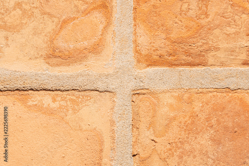 Terracotta clay tiles forming a textured surface with sandy grout lines