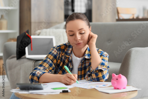 Student debt and financial stress, young woman calculating education costs an...