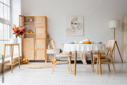 Autumn home interior, cozy dining room with seasonal fall decor and pumpkins ...