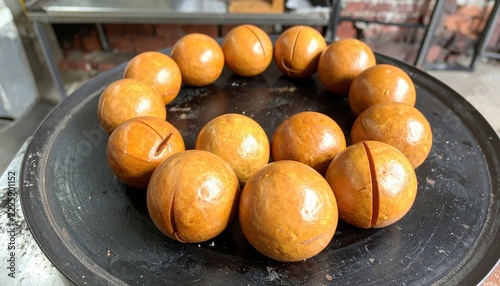 Golden Brown Toasted Brazil Nuts Arranged in a Circular Pattern on a Dark Surface