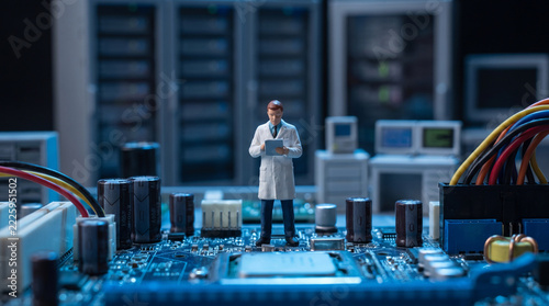 Miniature scientist in lab coat holding tablet standing on computer motherboard among capacitors and cables, hardware engineering and IT maintenance concept