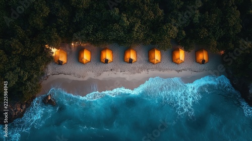 Aerial View Of Row Of Orange Tents On Sandy Beach At Night With Bioluminescent Glowing Blue Waves