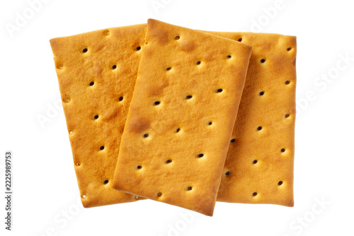 Three crisp rectangular biscuit crackers with holes isolated on a solid white background. Top view studio shot of delicious golden baked snack food, detailed macro view.