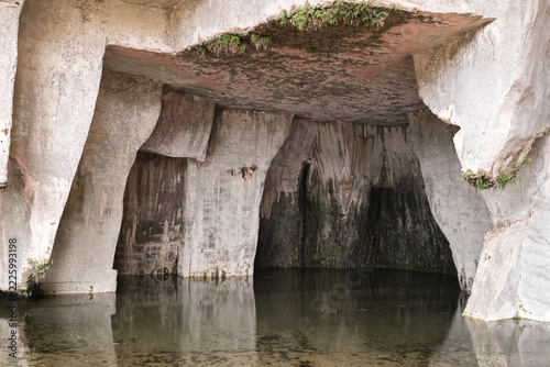 Interior of the limestone cave with reflected water in the Grotta dei Cordari in Syracuse, Italy