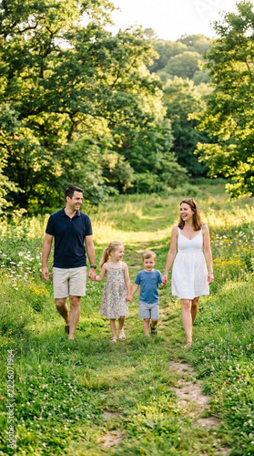 Happy Family Walking in Summer Nature Path Parents and Two Kids Holding Hands Outdoors