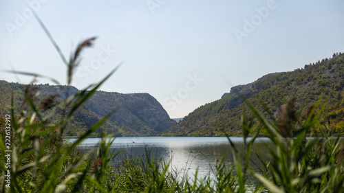 Freshwater lake framed by reeds and rocky hills, illustrating wetland habitat, water conservation, biodiversity protection and healthy inland aquatic ecosystems