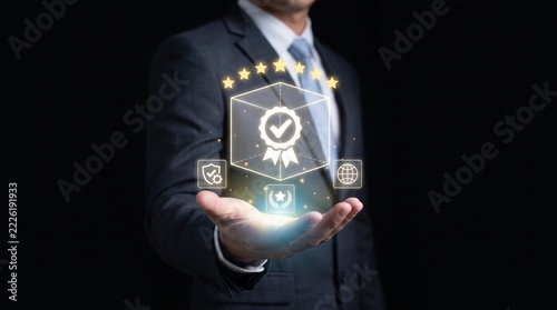 Businessman holding glowing virtual icon showing superior product quality standard