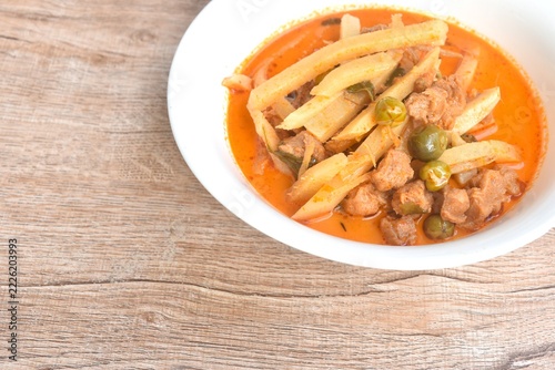 spicy boiled slice fresh bamboo shoot with gluten in coconut milk Thai red curry soup vegetarian fusion food on bowl