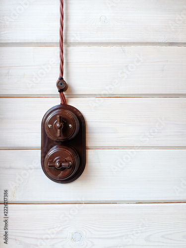 Vintage electric switch on white wooden wall. Copy space for text.