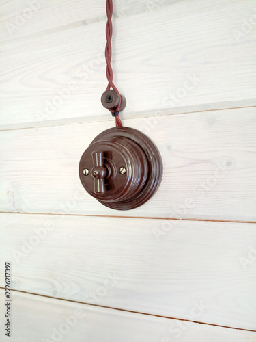 Vintage light switch on a white wooden wall, closeup of photo