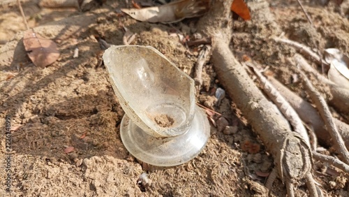 Broken glass that was thrown away a long time ago is lying on the ground.